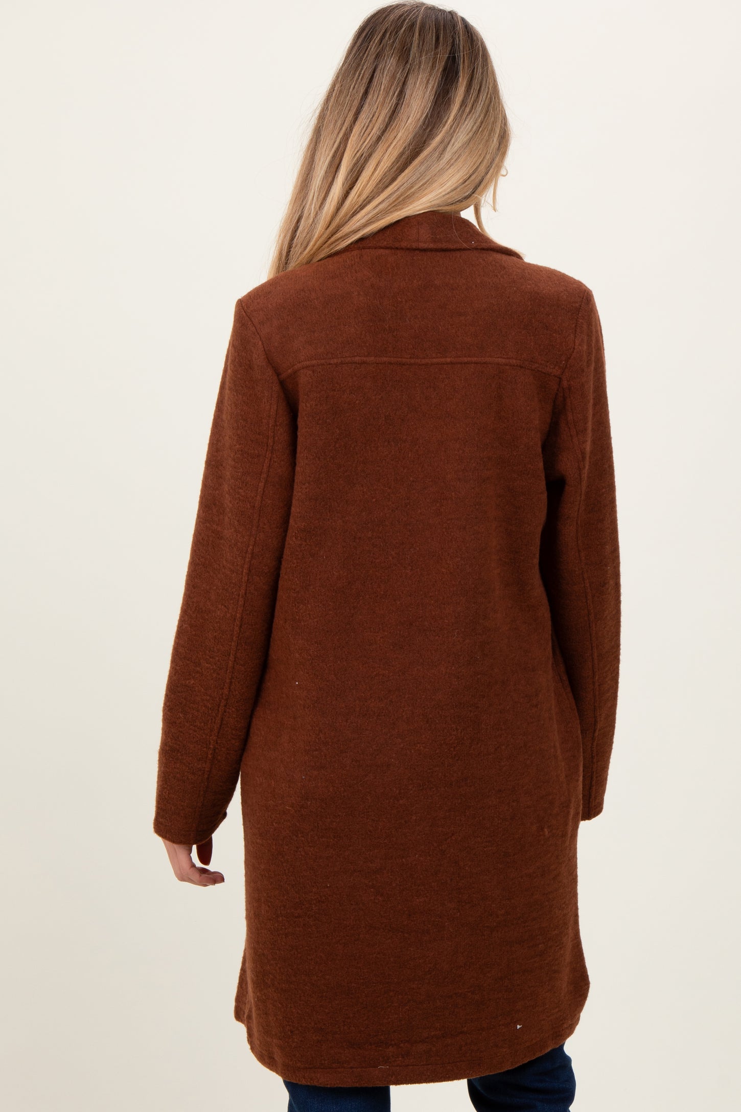 woman wearing a cozy brown maternity coat, styled with a relaxed fit and long sleeves, viewed from the back