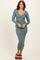 woman wearing a teal ribbed midi dress with long sleeves and a deep v-neckline