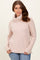 woman wearing a light pink turtleneck sweater with ribbed texture and side slits, paired with blue jeans