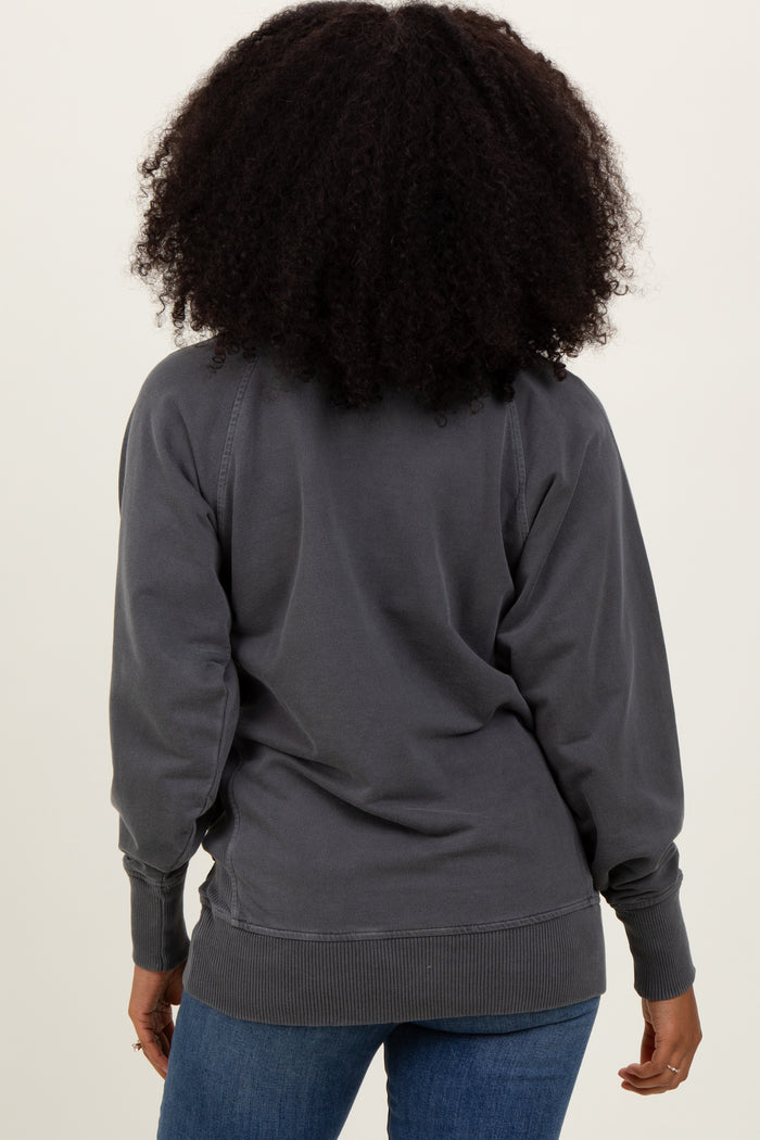 woman wearing a gray oversized sweatshirt, viewed from the back with a relaxed fit and ribbed cuffs