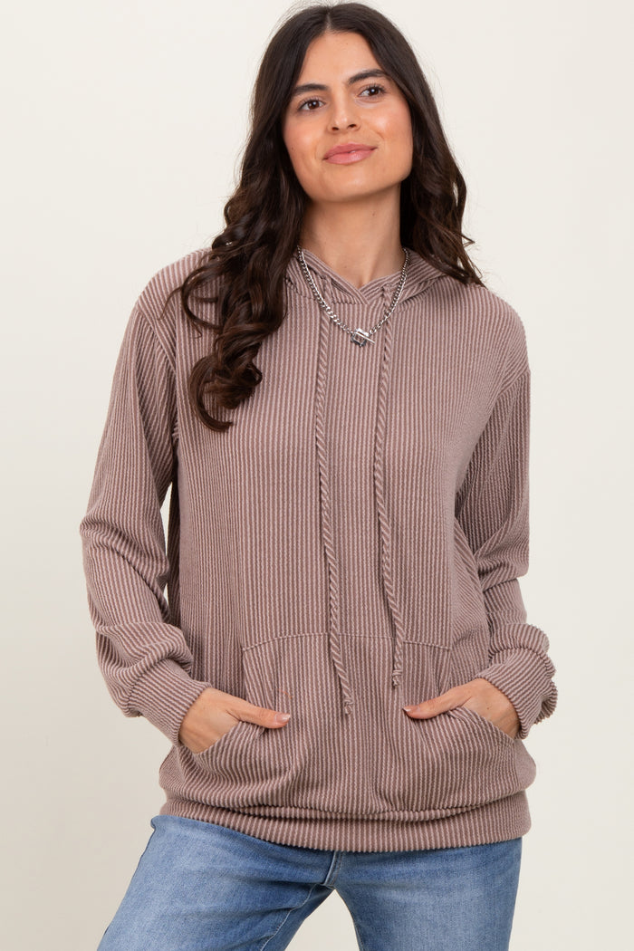 woman wearing a mauve ribbed hoodie with a drawstring and front pockets, styled with blue jeans