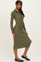 woman wearing a long sleeve olive green ribbed midi dress with a collar and button details, standing with one hand on her hip