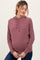 woman wearing a striped maroon maternity hoodie and gently cradling her baby bump