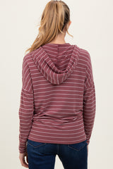 woman wearing a maroon and white striped maternity hoodie with a relaxed fit and a hood, viewed from the back