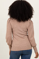 woman wearing a brown ribbed knit sweater with puff sleeves, viewed from the back