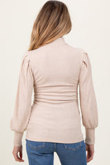woman wearing a beige ribbed maternity top with puff sleeves and a fitted bodice, viewed from the back