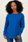 woman wearing a bright blue long sleeve top with a relaxed fit and scoop neckline