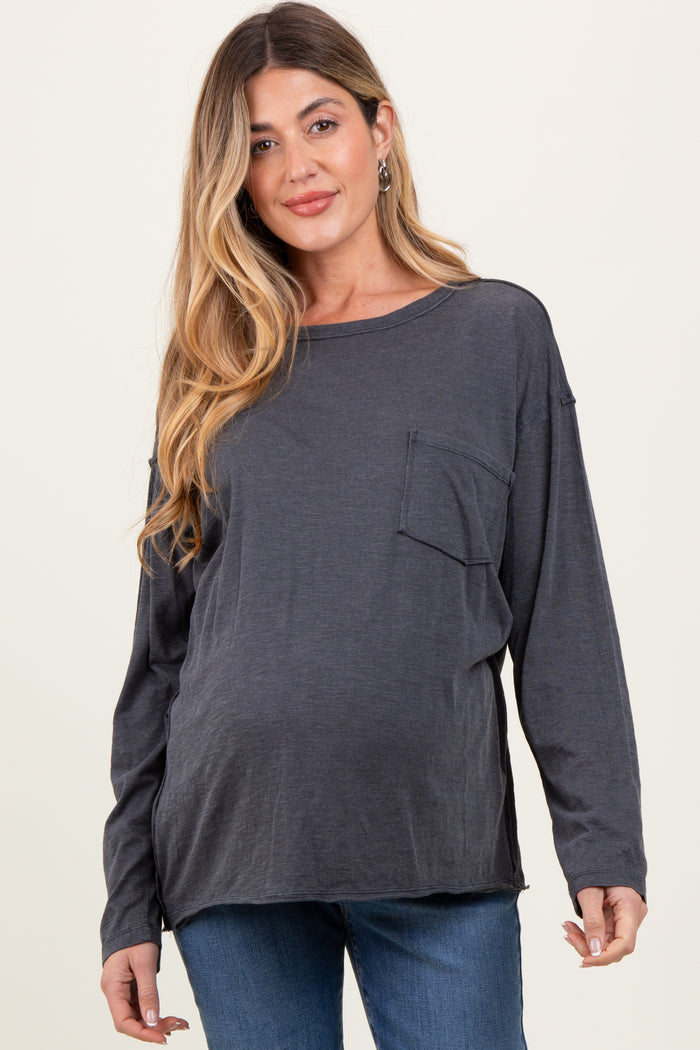 woman wearing a dark gray long sleeve maternity top with a front pocket and showing her baby bump