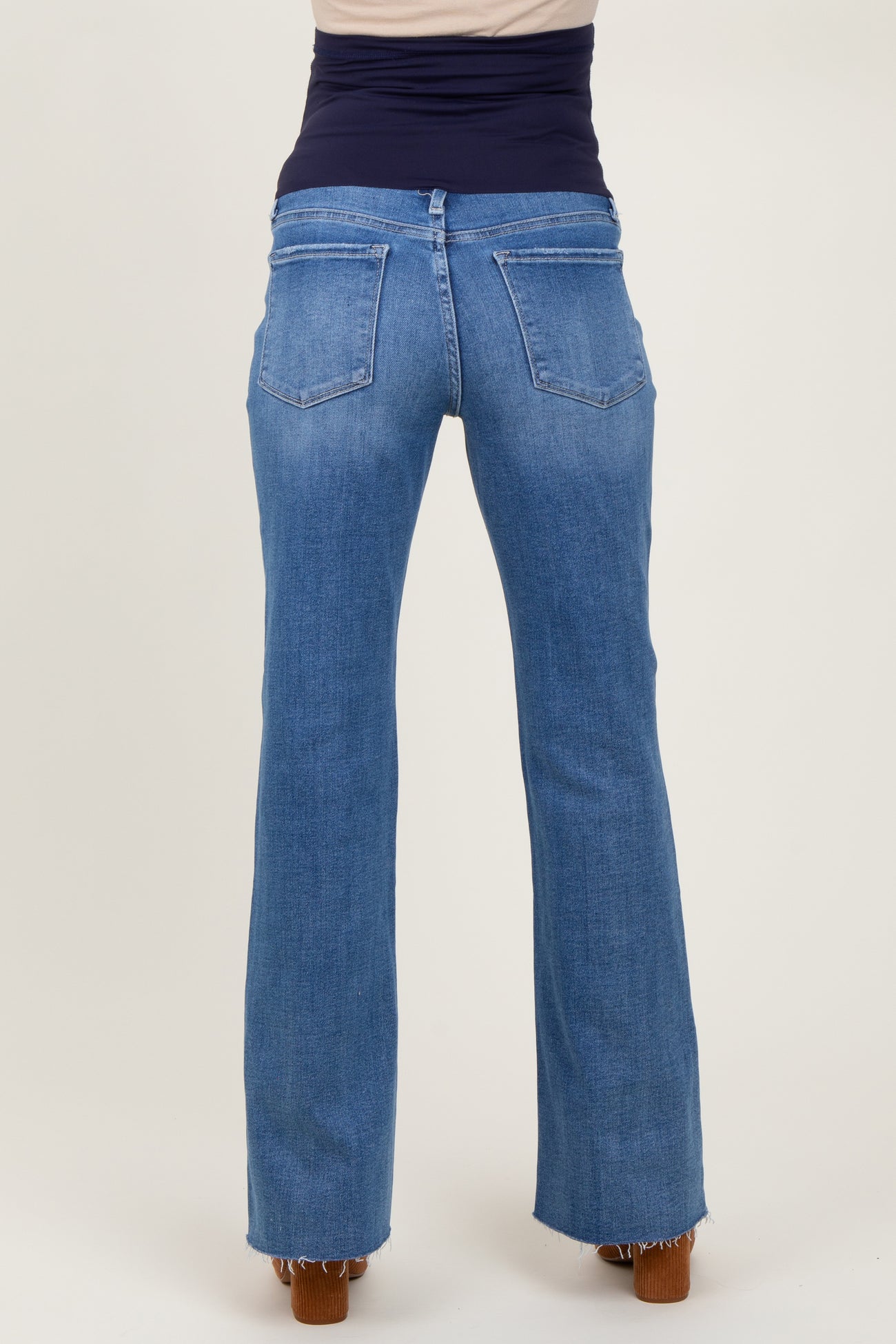 woman wearing light blue maternity flared jeans, viewed from the back