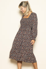 woman wearing a floral print midi dress with a square neckline and puffed sleeves