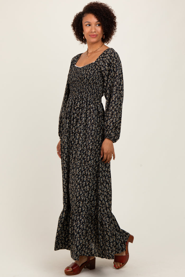 woman wearing a long black floral maxi dress with puff sleeves and a square neckline