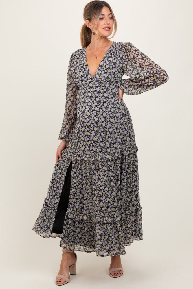 woman wearing a black floral maxi maternity dress with long sleeves and a deep v-neck, showcasing her baby bump
