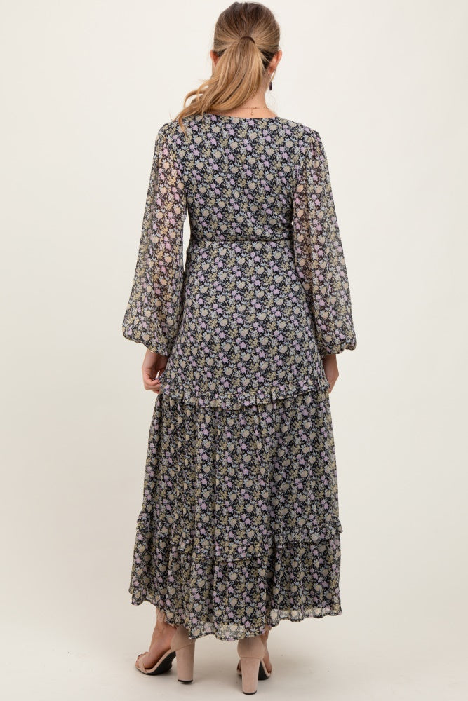 woman wearing a floral black maternity maxi dress with long sleeves and tiered hem from the back
