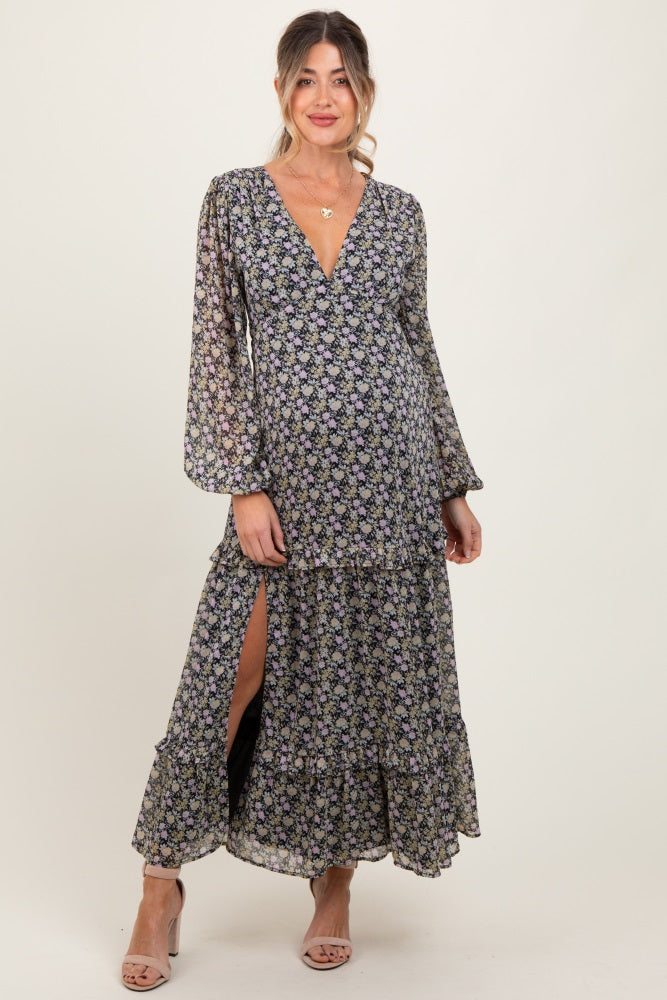 woman wearing a floral maternity maxi dress with long sleeves and a v-neckline, featuring a slit and ruffled tiers