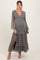woman wearing a floral maternity maxi dress with long sleeves and a v-neckline, featuring a slit and ruffled tiers