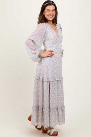 woman wearing a floral long sleeve maxi dress with ruffle details and a deep v-neckline, smiling and posing