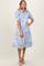 woman wearing a light blue floral midi dress with puff sleeves and a collar, standing and smiling