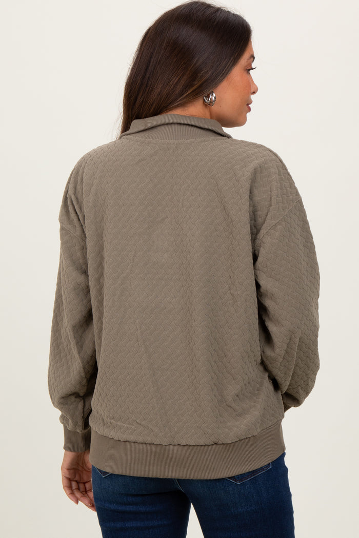 woman wearing a green quilted maternity jacket with a relaxed fit and ribbed cuffs, showing her back