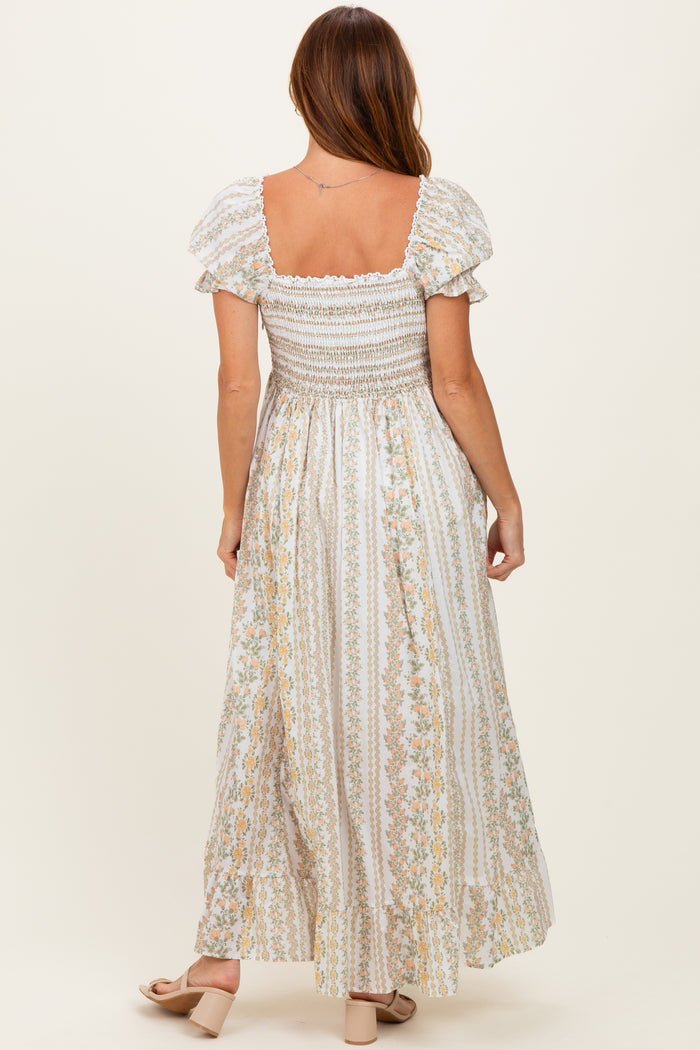 woman wearing a white floral maxi dress with puff sleeves and a smocked bodice, shown from the back