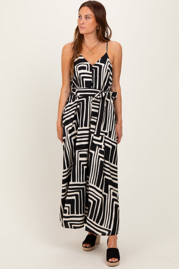 woman wearing a black and white patterned maxi dress with a tie waist and spaghetti straps