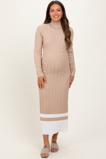 woman wearing a beige maternity dress with long sleeves and a ribbed texture, showing her baby bump