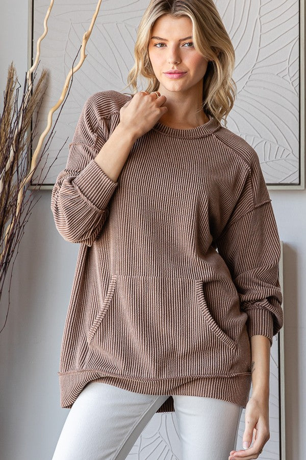 woman wearing a brown ribbed oversized sweatshirt with front pockets and a relaxed fit