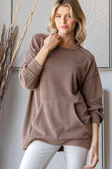 woman wearing a brown ribbed oversized sweatshirt with front pockets and a relaxed fit