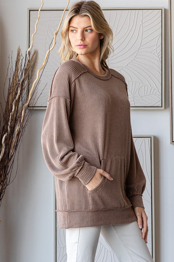 woman wearing a brown ribbed long sleeve oversized sweater with pouch pockets and relaxed fit