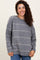 woman wearing a gray striped oversized sweater with a round neckline and smiling