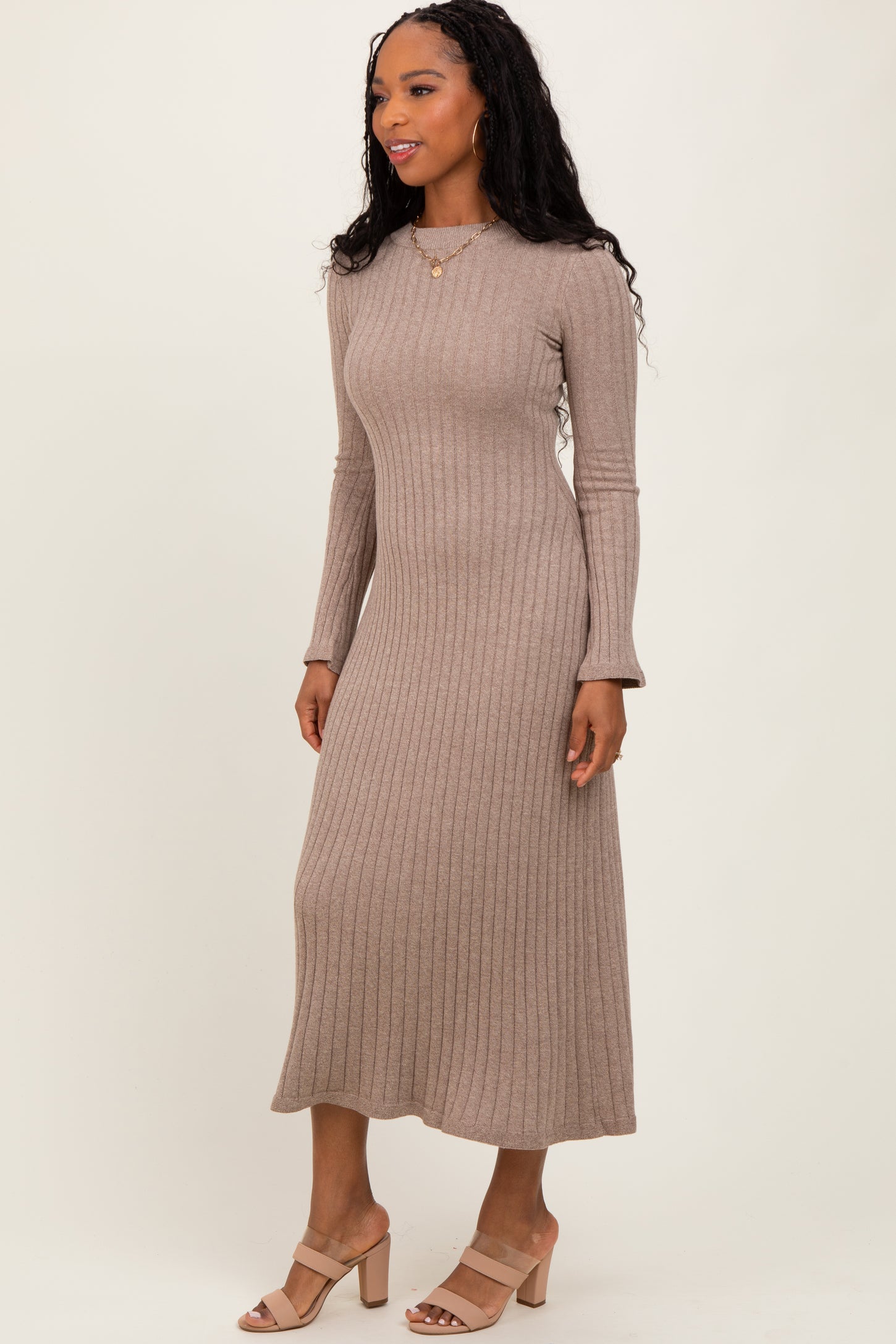 woman wearing a taupe ribbed knit long sleeve dress with a fitted silhouette and a midi length