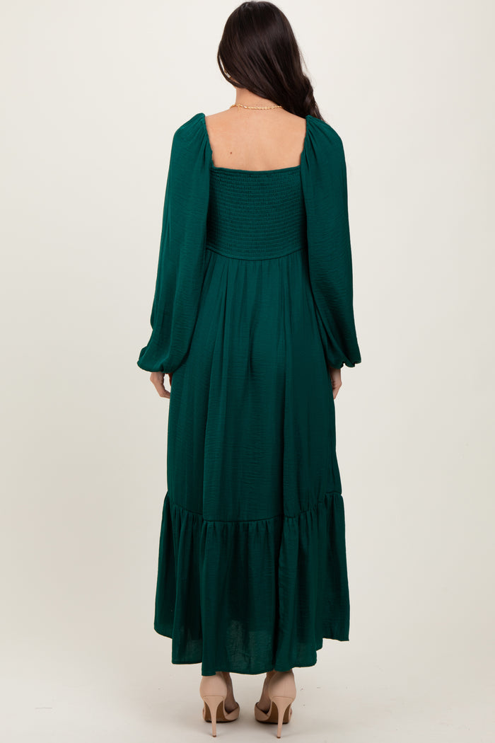 woman wearing a long green smocked back dress with puff sleeves and a tiered skirt, viewed from the back