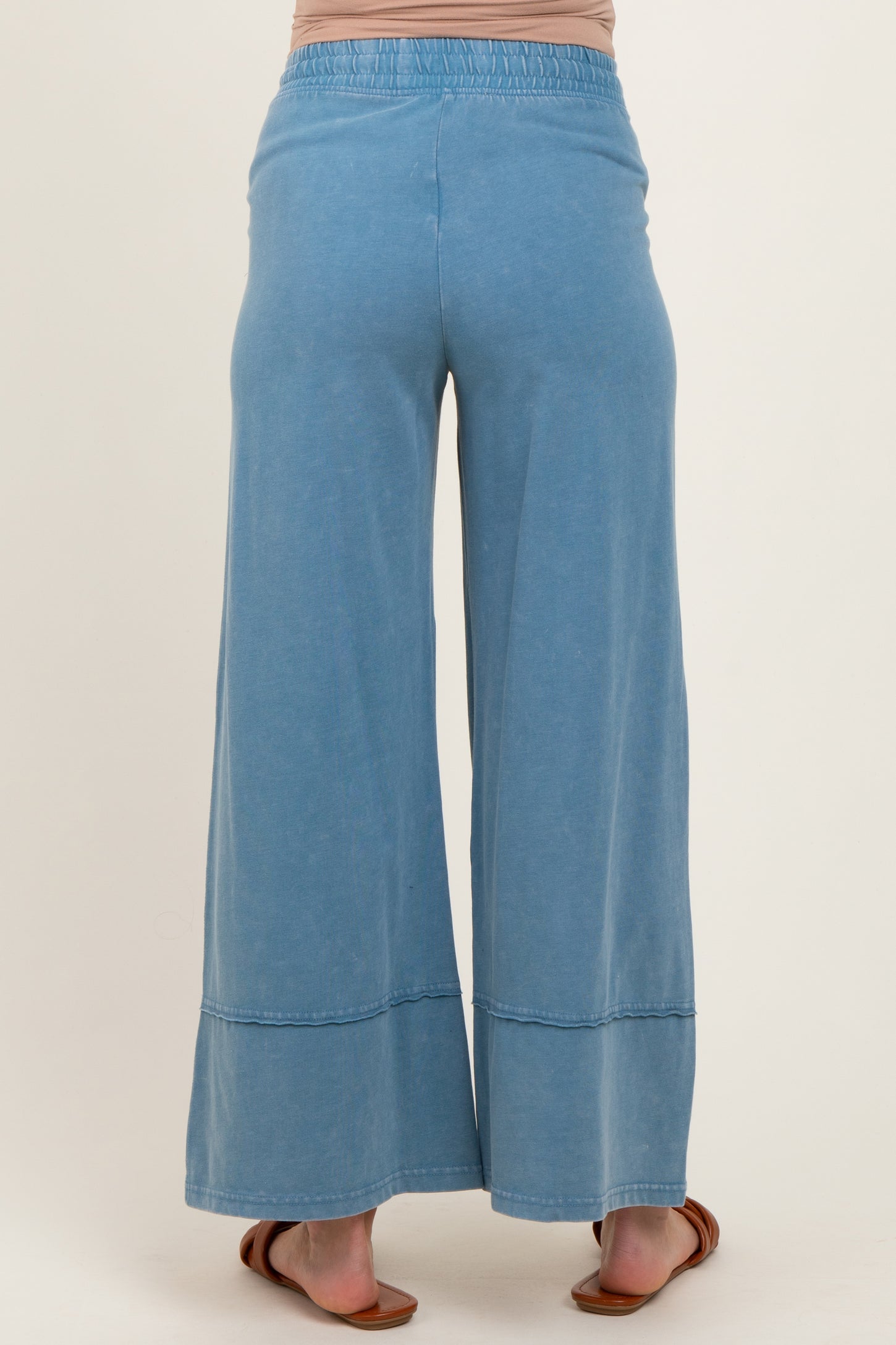 woman wearing light blue maternity wide-leg pants, showing the back view with an elastic waistband