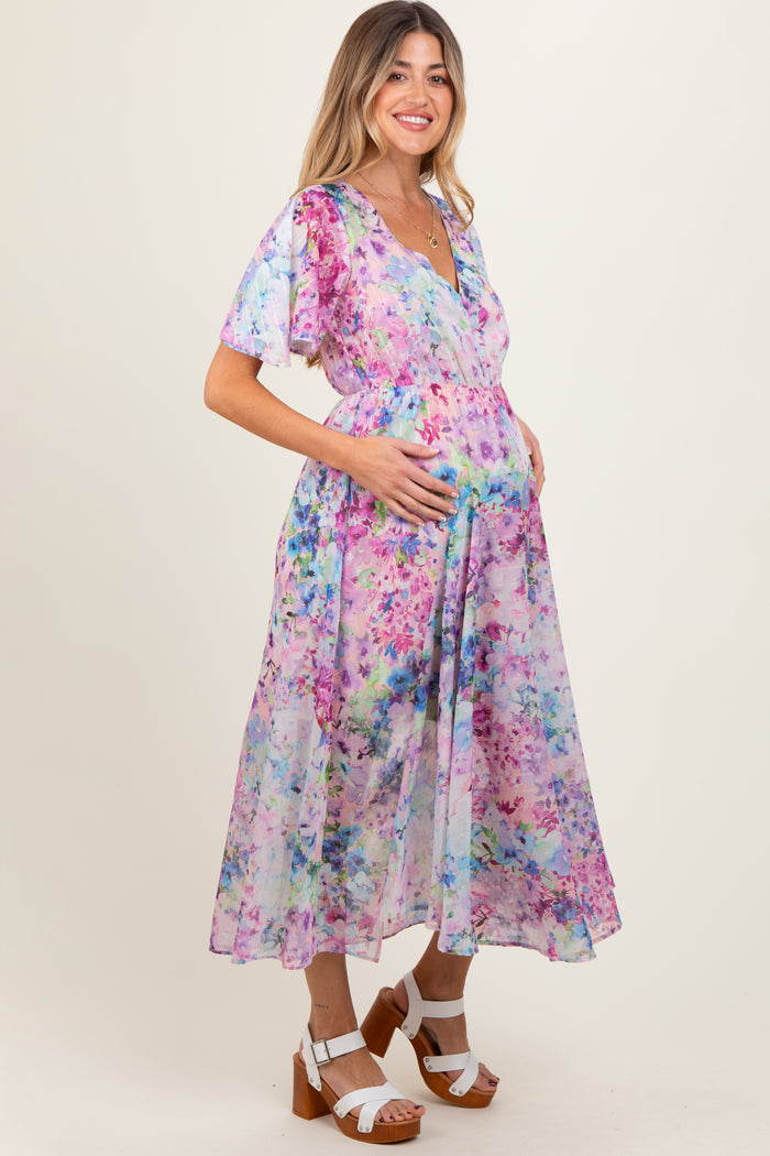 woman wearing a floral maternity dress with flutter sleeves and a baby bump visible