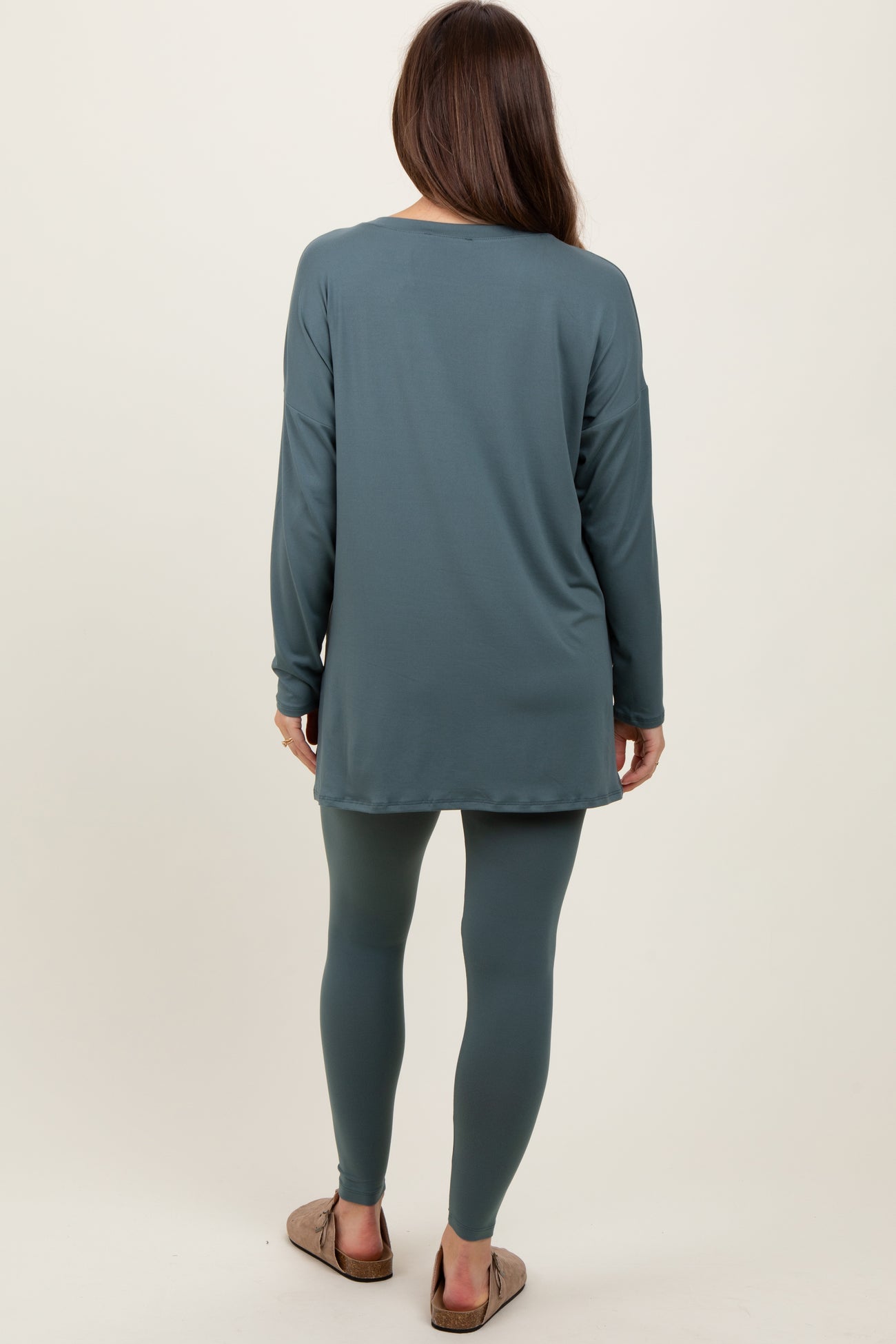 woman wearing a teal maternity tunic top and matching leggings, viewed from the back