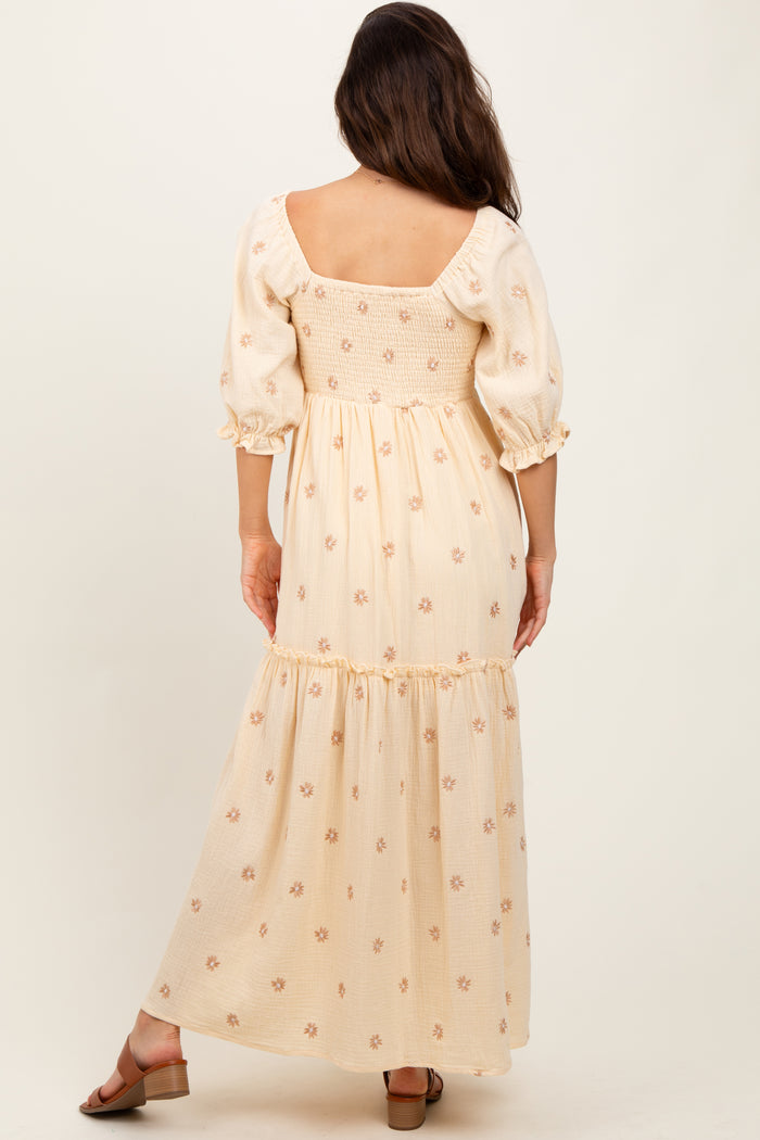 woman wearing a cream floral maxi dress with puff sleeves and a smocked bodice, viewed from the back