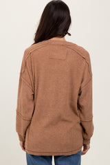 woman wearing a brown oversized ribbed sweater, showing the back view with relaxed fit and long sleeves
