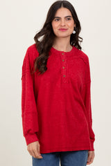 woman wearing a red ribbed long sleeve henley top with buttons and relaxed fit