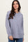 woman wearing a gray ribbed long sleeve henley top with button detail and relaxed fit