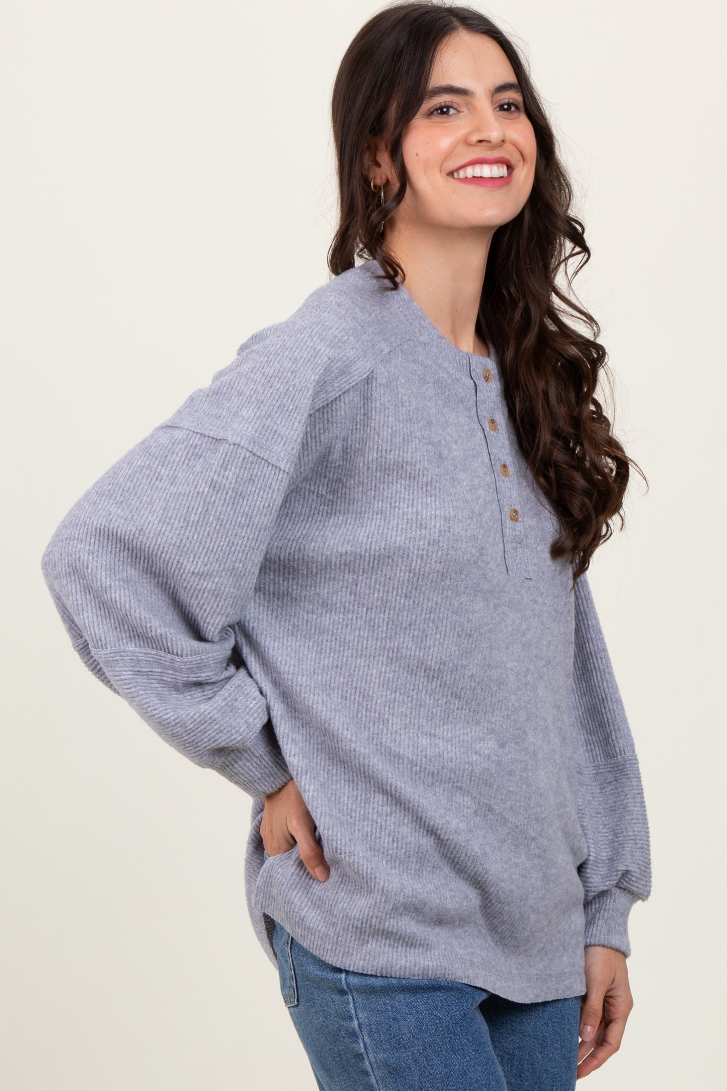 woman wearing a gray ribbed long sleeve henley top with buttons and relaxed fit