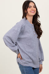woman wearing a gray ribbed long sleeve henley top with buttons and relaxed fit