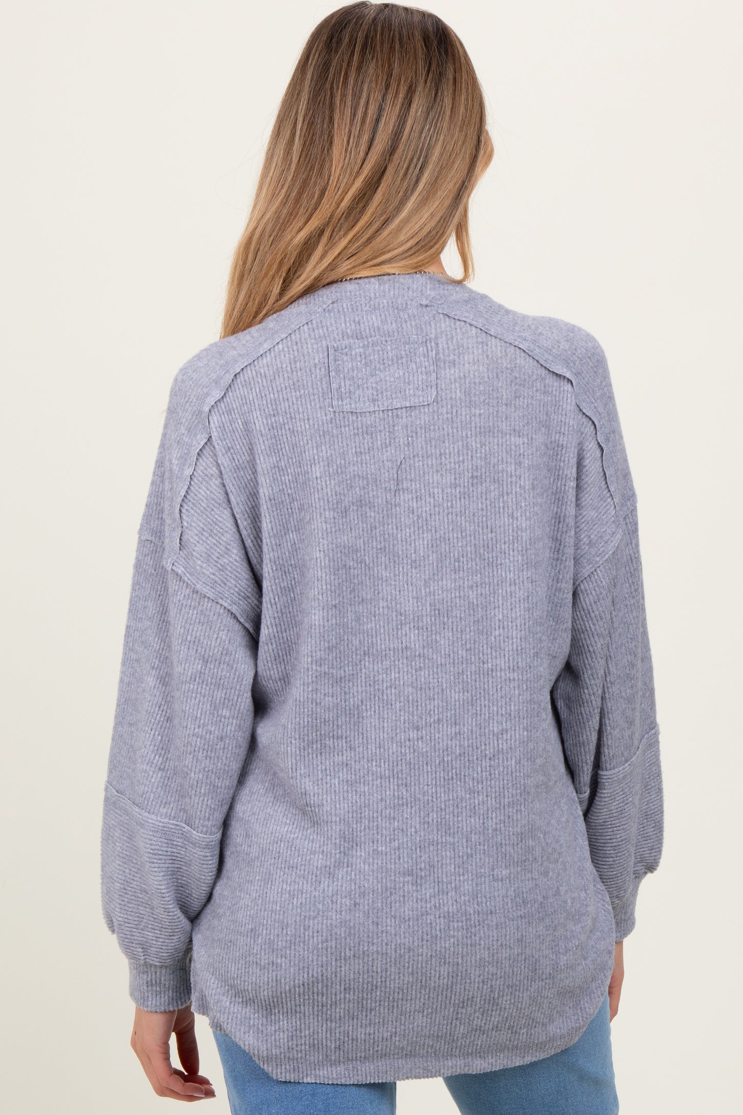 woman wearing a gray long sleeve maternity sweater with a relaxed fit and ribbed texture, showing the back view