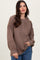 woman wearing a brown ribbed long sleeve henley top with button details and loose fit