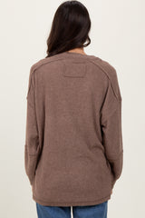 woman wearing a brown oversized ribbed sweater, showing the back view and relaxed fit