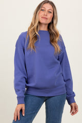 woman wearing a purple long sleeve sweatshirt paired with blue jeans