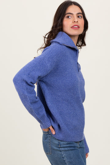 woman wearing a light purple knit pullover sweater with a folded collar and side pockets, paired with jeans