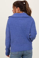 woman wearing a cozy blue maternity sweater with a wide collar and ribbed hem, showcasing a relaxed fit from the back