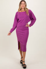 woman wearing a vibrant purple long sleeve sweater and matching midi skirt with a side slit