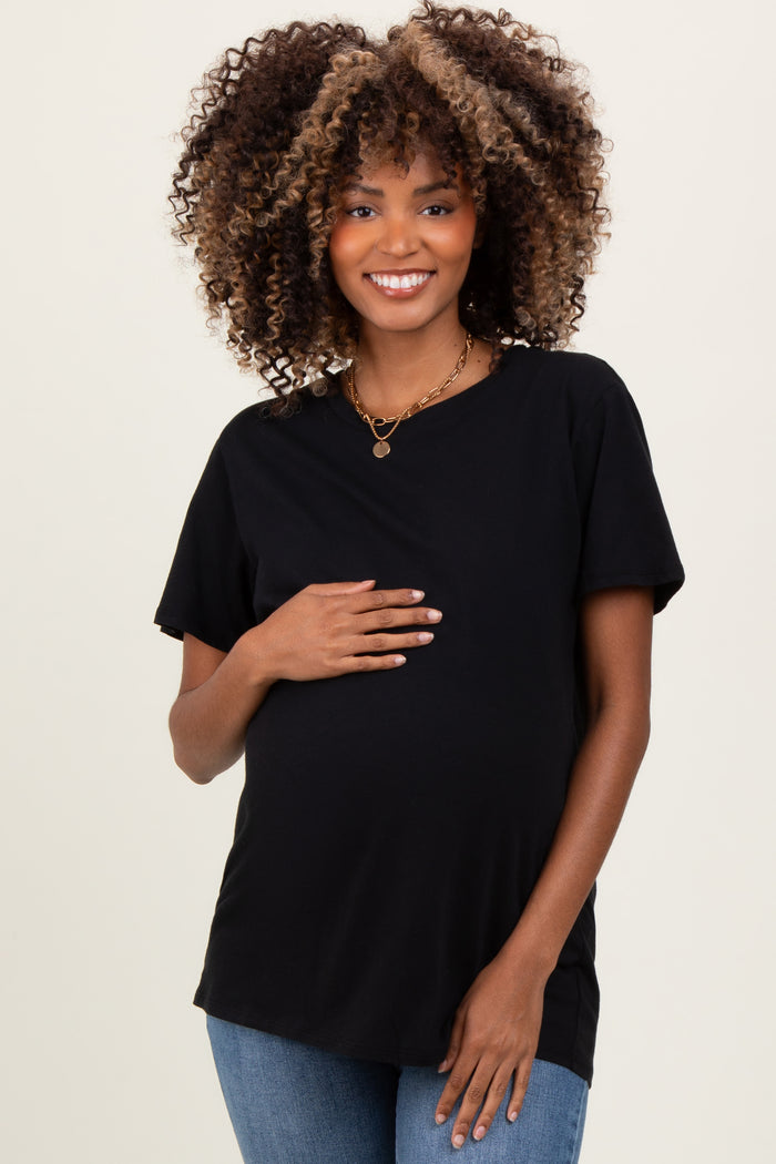 woman wearing a black short sleeve maternity top and showing her baby bump