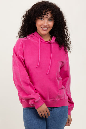 woman wearing a bright pink oversized hoodie with drawstrings and relaxed fit, paired with blue jeans