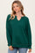 woman wearing a green long sleeve waffle knit top with a v-neck and relaxed fit.